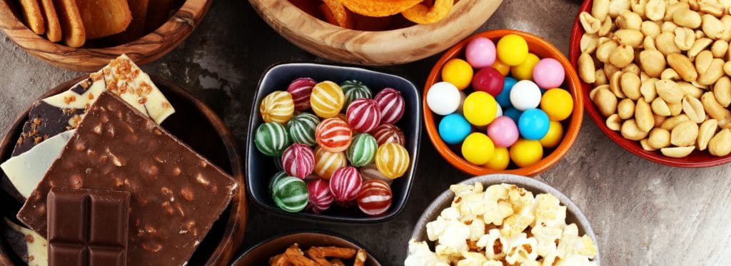 Bowls of sweets and snack foods to avoid eating while wearing temporary veneers.