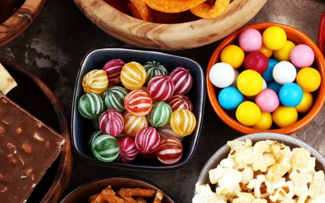 Bowls of sweets and snack foods to avoid eating while wearing temporary veneers.