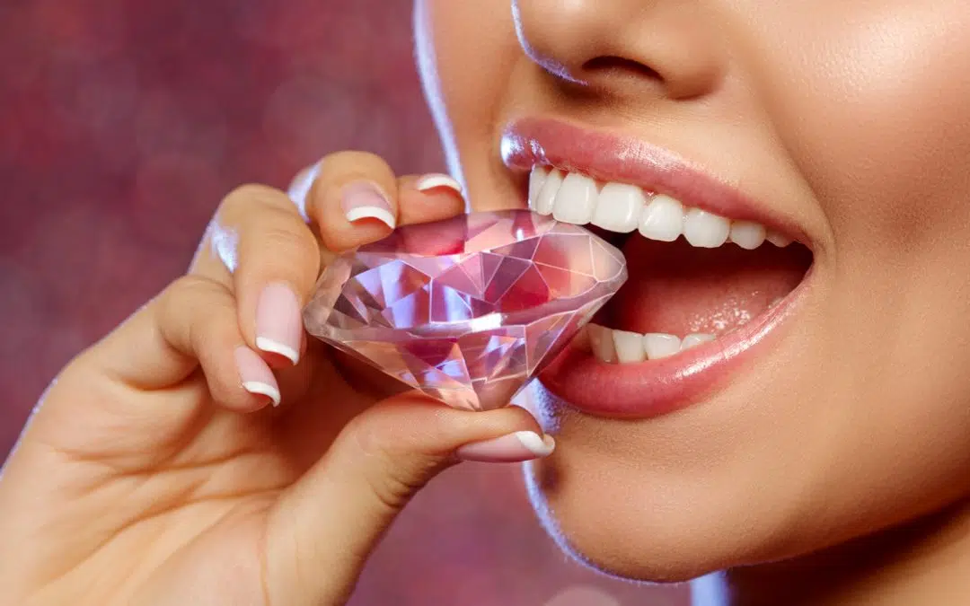 Happy woman bites down on large diamond with beautiful, strong white teeth
